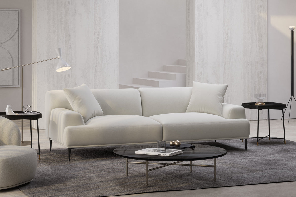 Warm minimalist living room with a white fabric sofa, natural wood tones, and layered neutral textiles