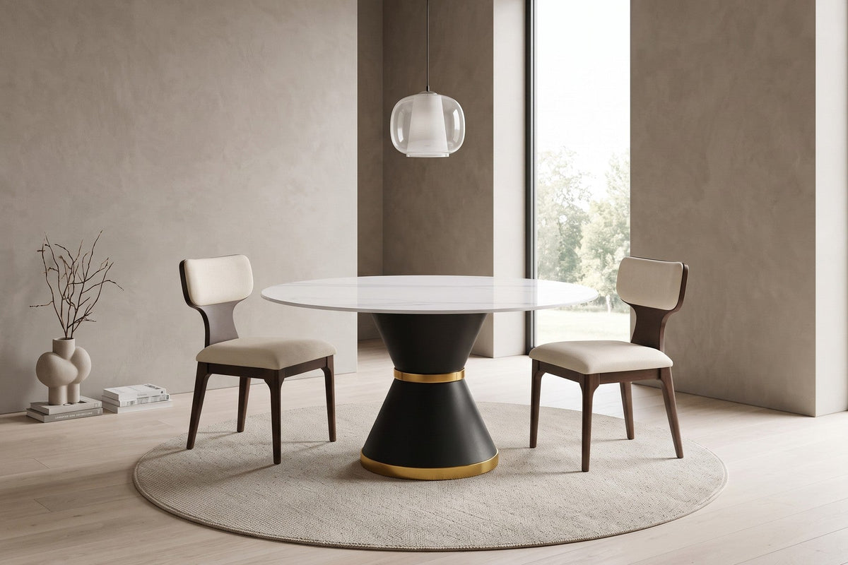 Round white sintered stone dining table on a black hourglass pedestal with two upholstered dining chairs