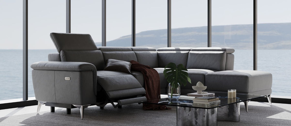 Millet grey leather power reclining sectional with one seat reclined, by floor-to-ceiling windows