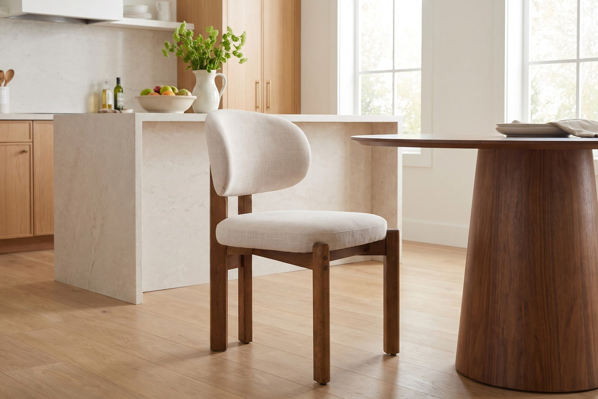 Daylight. In a bright kitchen, the rounded back softens a dark wood table.