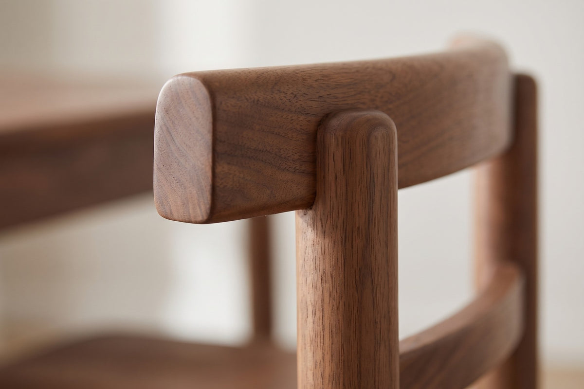 Albi Walnut Dining Chair: close-up of the rounded end of the thick top back rail where it passes the round back post, walnut grain visible