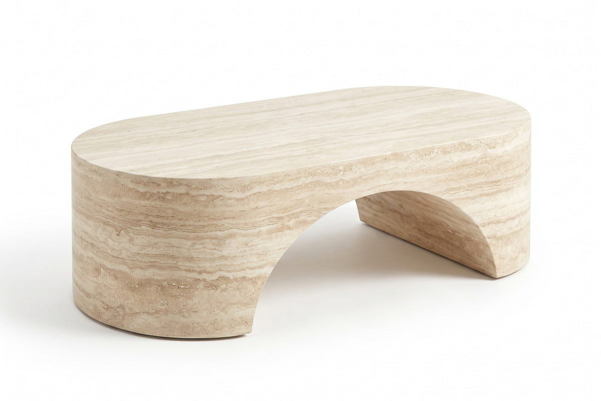 Alma oval sculpted coffee table in a cream travertine-look finish, three-quarter view from slightly above, showing the oval top and the arch under one long side on a white background