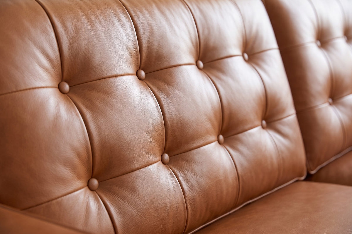 Amboise Cognac Button-Tufted Leather Sofa: close-up of a button-tufted back cushion, showing the leather-covered buttons and the soft folds of cognac leather around them