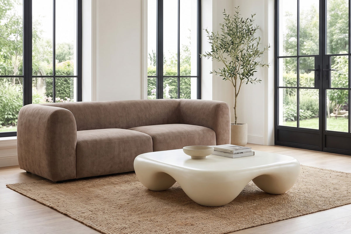 Daylight. On a jute rug by tall garden windows, the soft feet sit close to the floor.