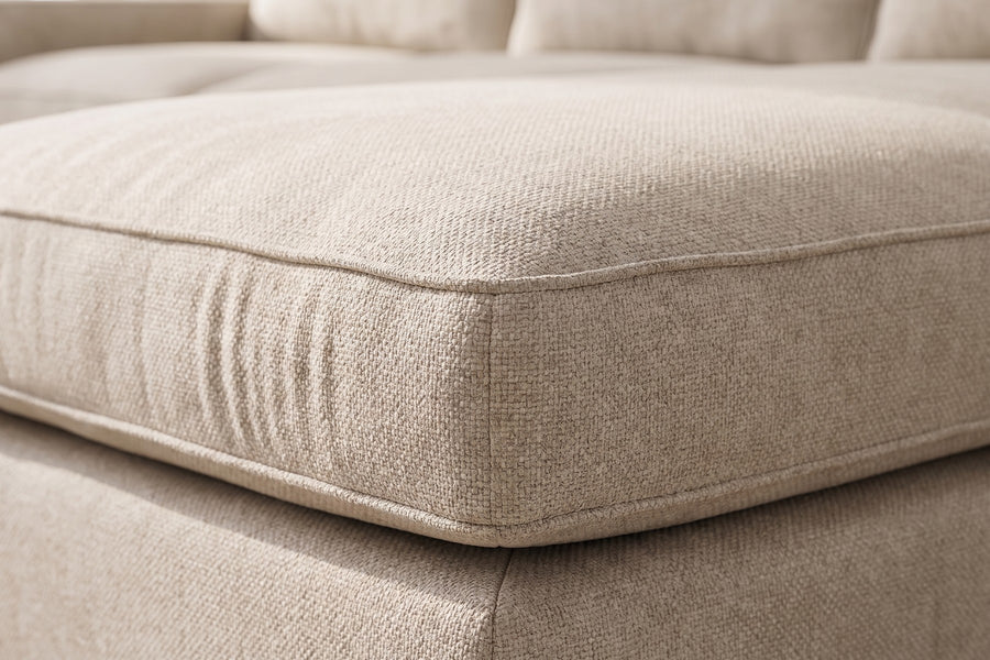 Annecy Modular L-Shaped Sectional: close-up of a seat cushion corner, showing the oatmeal chenille texture and the neat self-welted edge