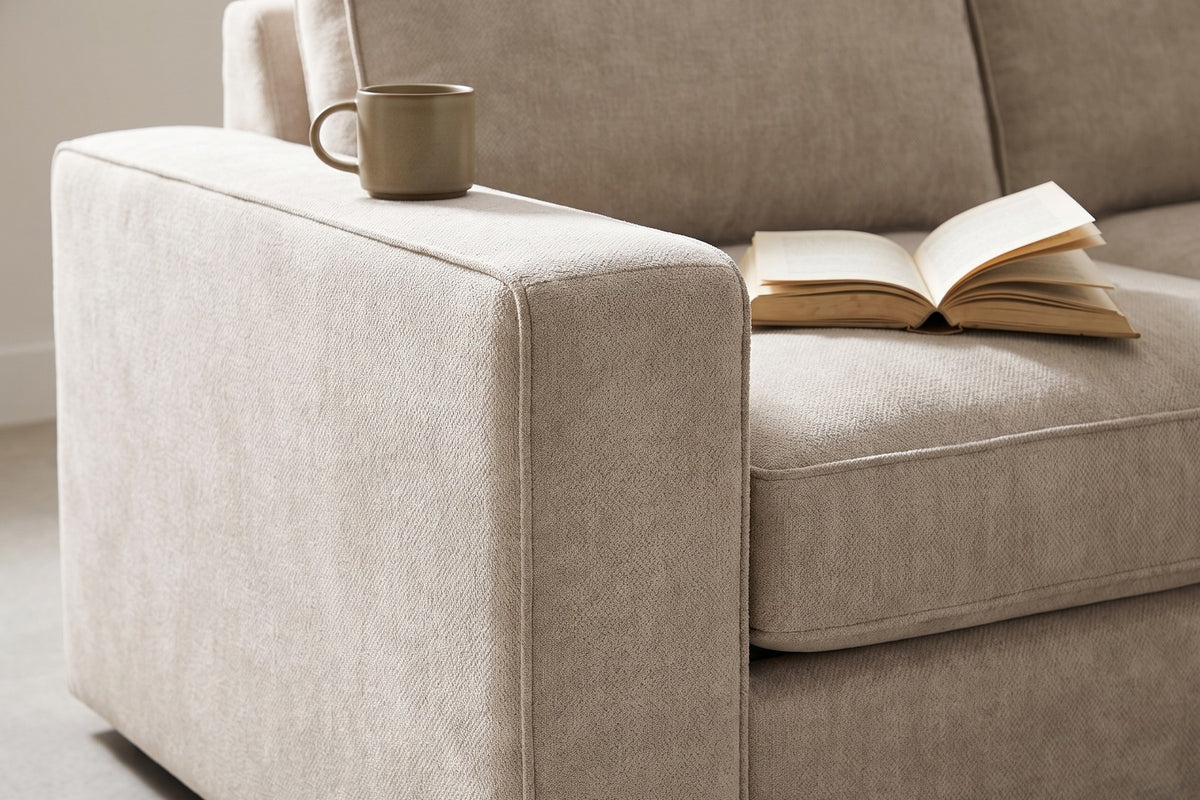 Annecy Modular L-Shaped Sectional: close-up of the wide flat-topped box arm with a ceramic cup and a book resting on it, chenille texture visible