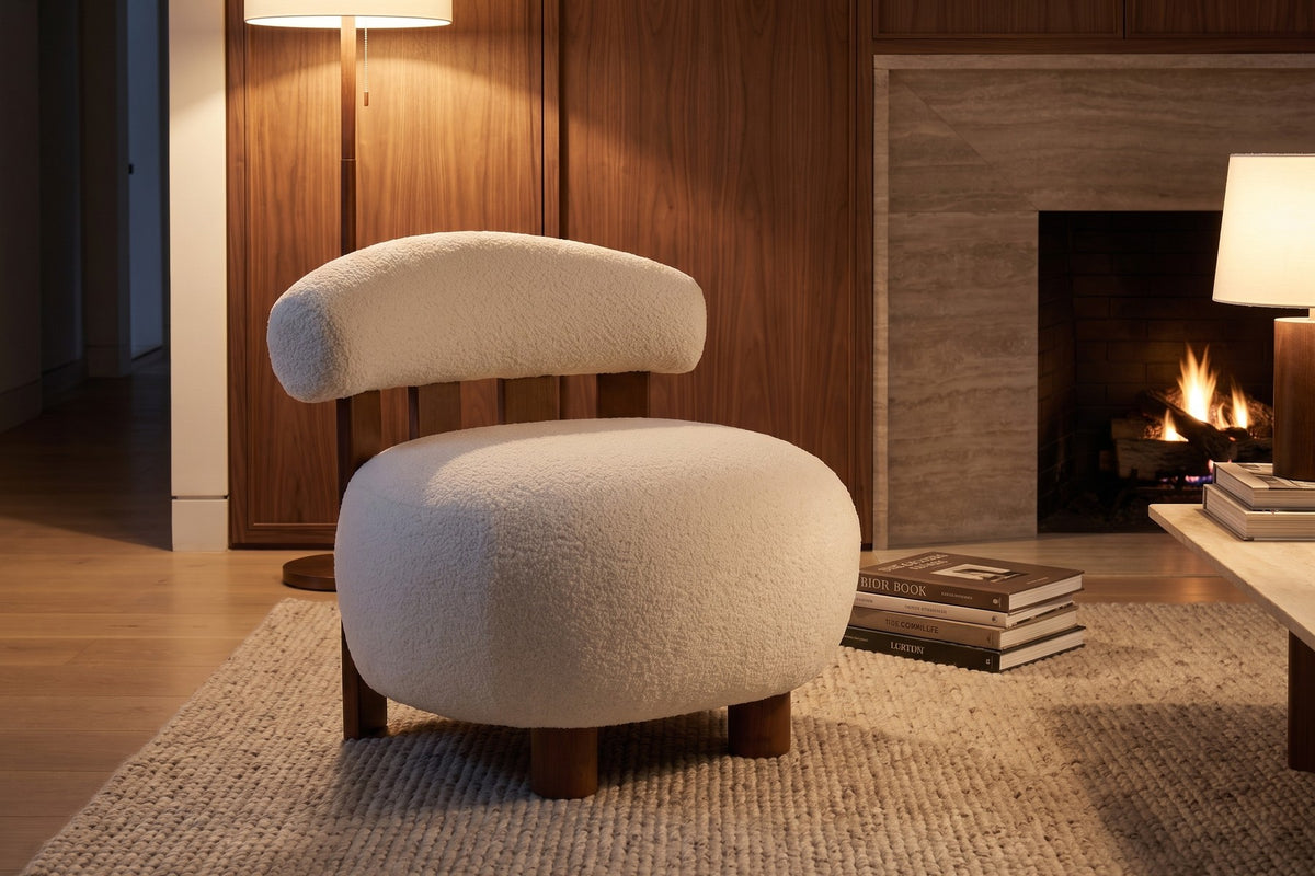 Anouk off-white bouclé slipper chair with a walnut-finish slatted back in a warm walnut-panelled living room in the evening