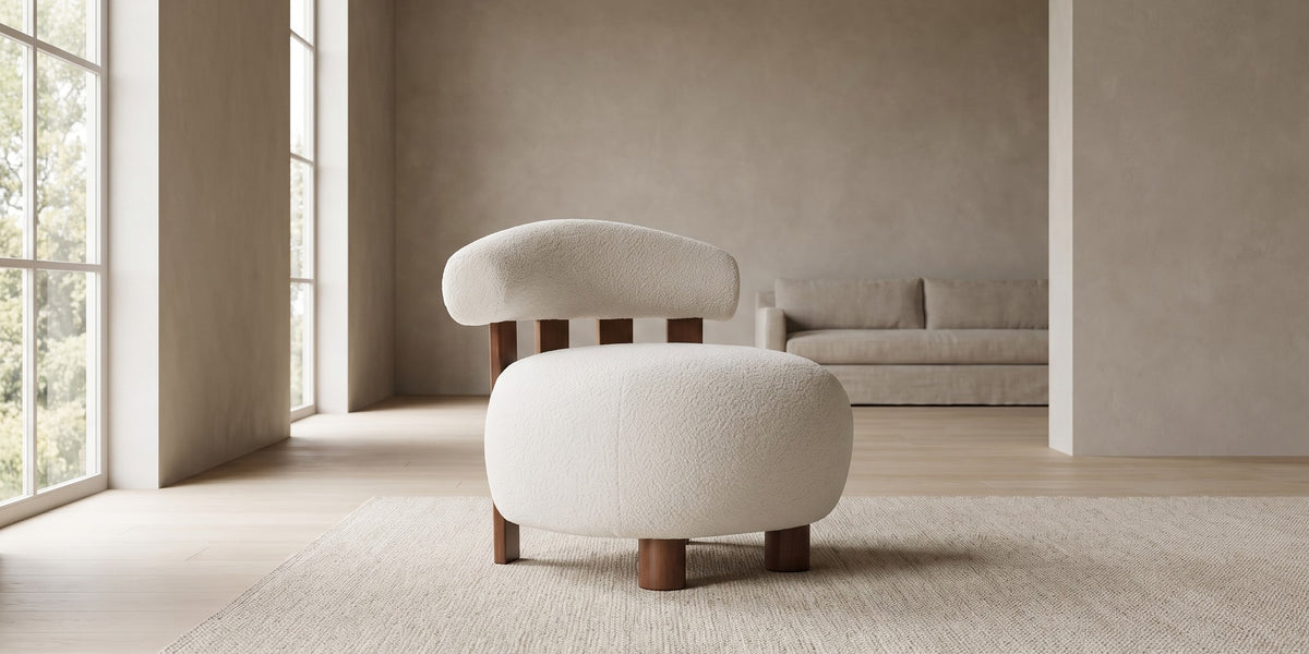 Anouk off-white bouclé slipper chair with a walnut-finish slatted back in a wide, calm living room