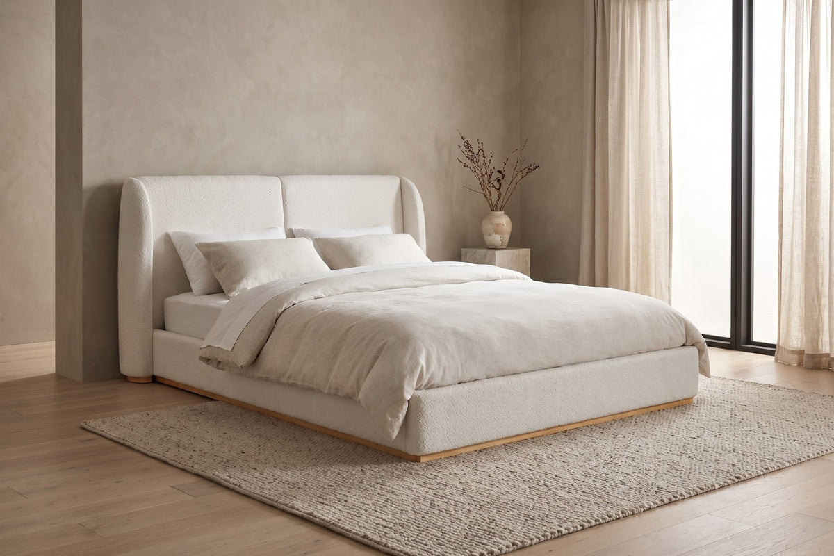 Apolline white bouclé platform bed with a wingback headboard in a calm, daylit bedroom