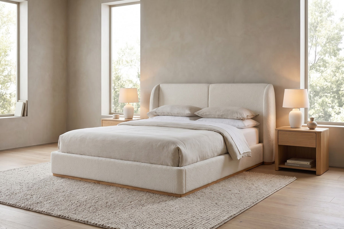Apolline white bouclé platform bed with a wingback headboard in a wide, calm bedroom