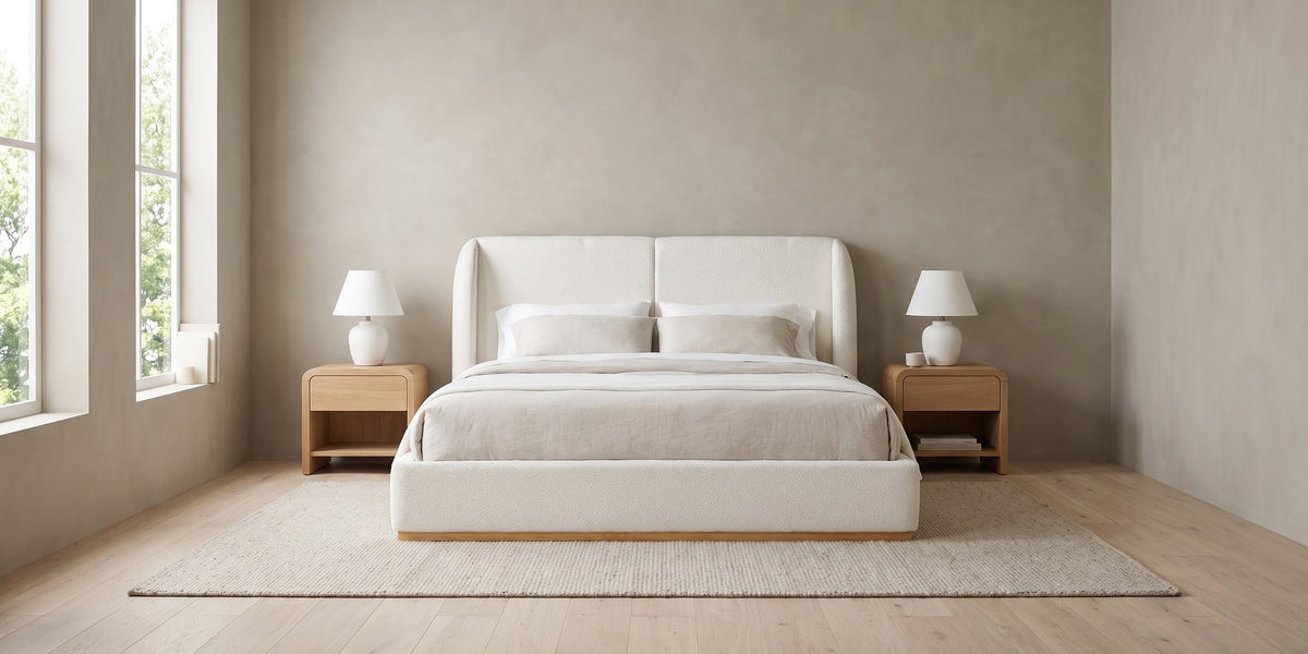 Apolline white bouclé platform bed with a wingback headboard in a wide, calm bedroom