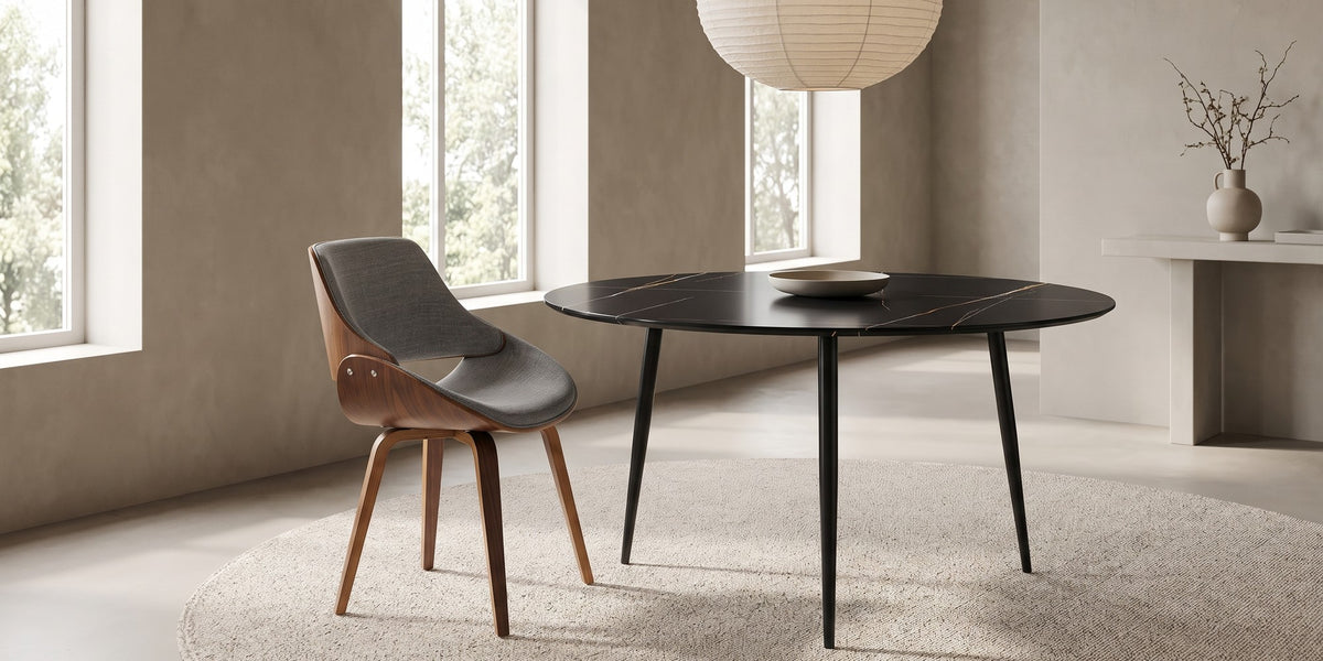 A Bastien chair at the round black Marais table in a wide, calm dining room