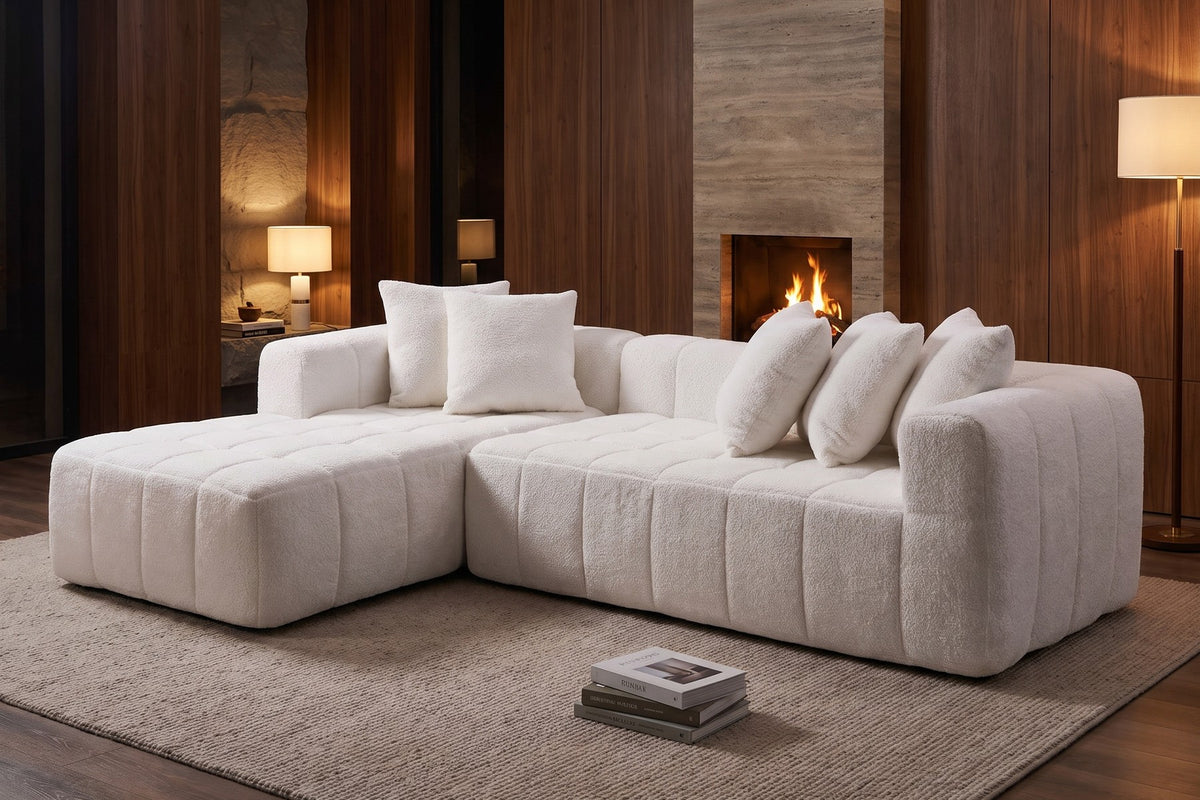 Batignolles white bouclé grid-tufted l-shaped sectional with left-facing chaise in a warm walnut-panelled living room in the evening