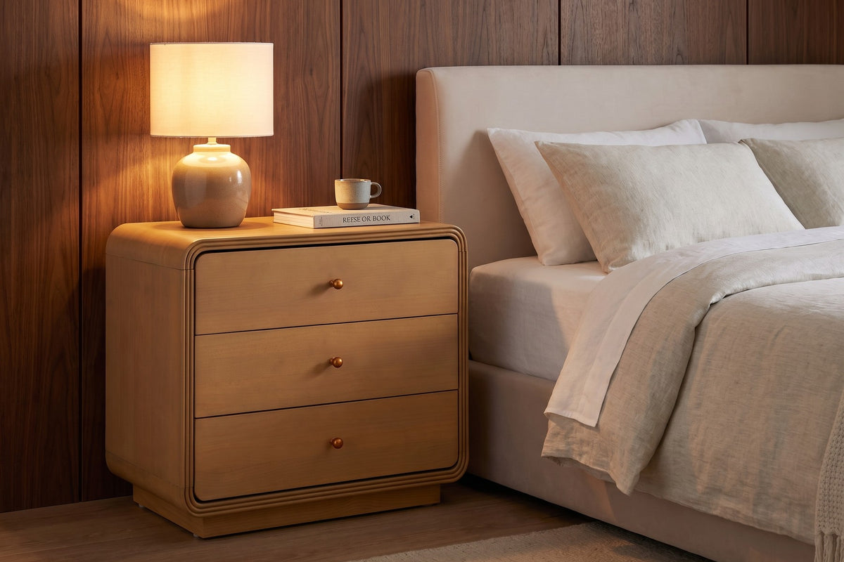 Lamp on. The wide top takes a lamp, a book and a cup, with three drawers below.