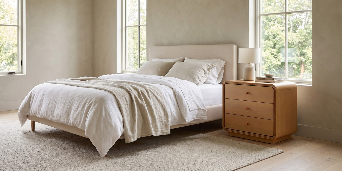 Belleville natural-finish 3-drawer nightstand with curved edges in a wide, calm bedroom
