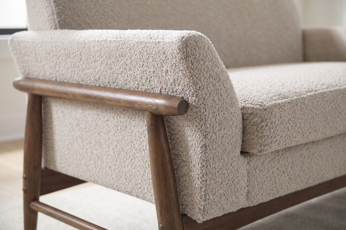 Close-up of the almond boucle on the flared arm with its walnut-finish rail (Bercy)