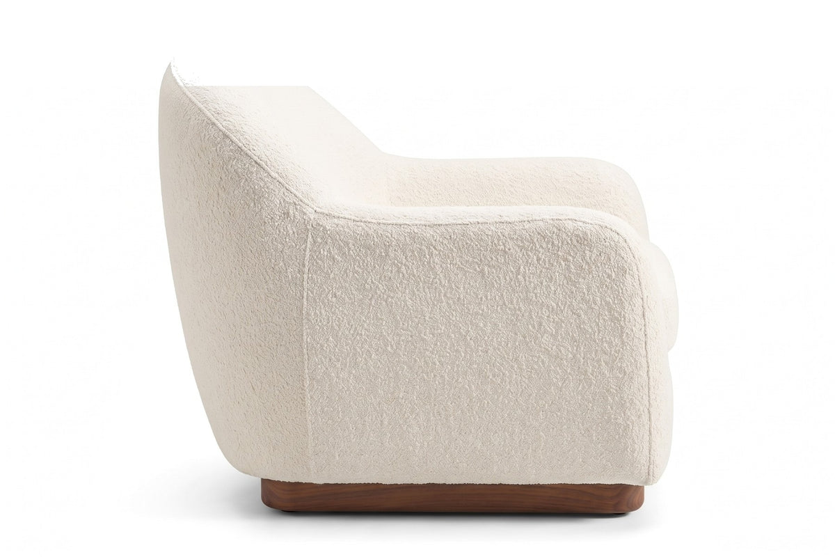 Biot Ivory Bouclé Lounge Chair, straight side view from the right at seat height, showing the back sloping down into the arm and the walnut plinth