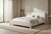 Capucine white boucle king platform bed with rounded rolled frame in a calm bedroom with greige plaster walls and a pale oak floor