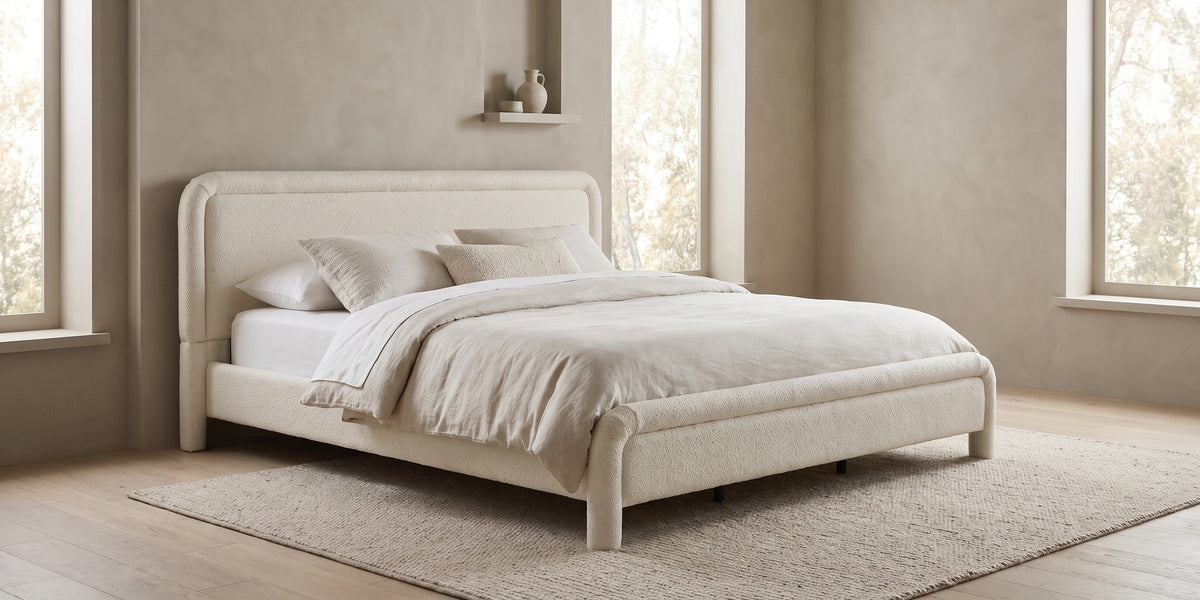 Capucine white boucle king platform bed with rounded rolled frame in a wide room view