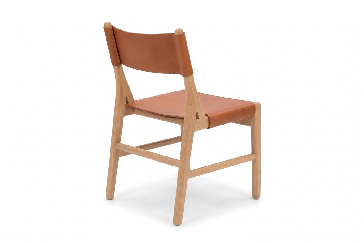 Cassis Leather Sling Dining Chair, three-quarter view from the back right, showing the leather back band from behind
