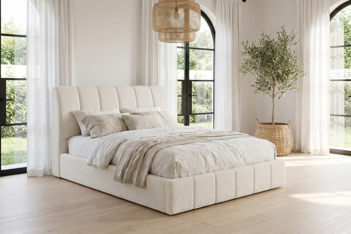 Daylight. Under tall arched windows, the white bouclé keeps the whole room light.
