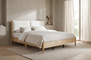 Delphine california king natural wood bed with white upholstered headboard in a calm bedroom with greige plaster walls and a pale oak floor
