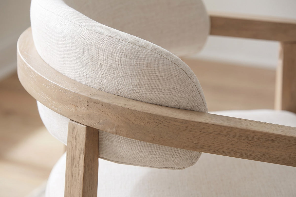 Close-up of the padded beige back band curving inside the light ash wooden arm rail (Elise)