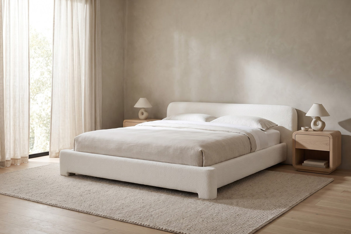 Elodie low white bouclé platform bed with rounded rails in a calm, daylit bedroom