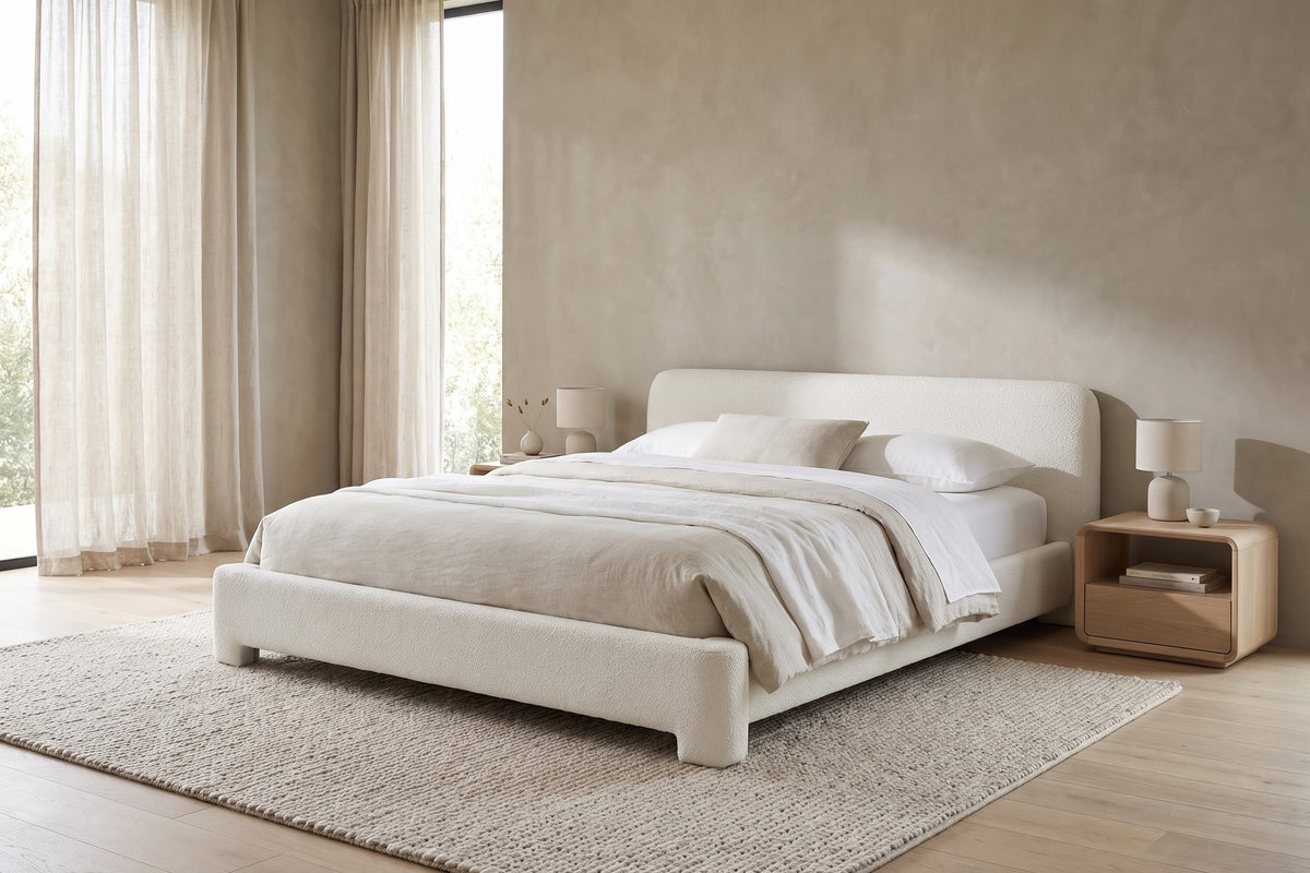 Elodie low white bouclé platform bed with rounded rails in a calm, daylit bedroom