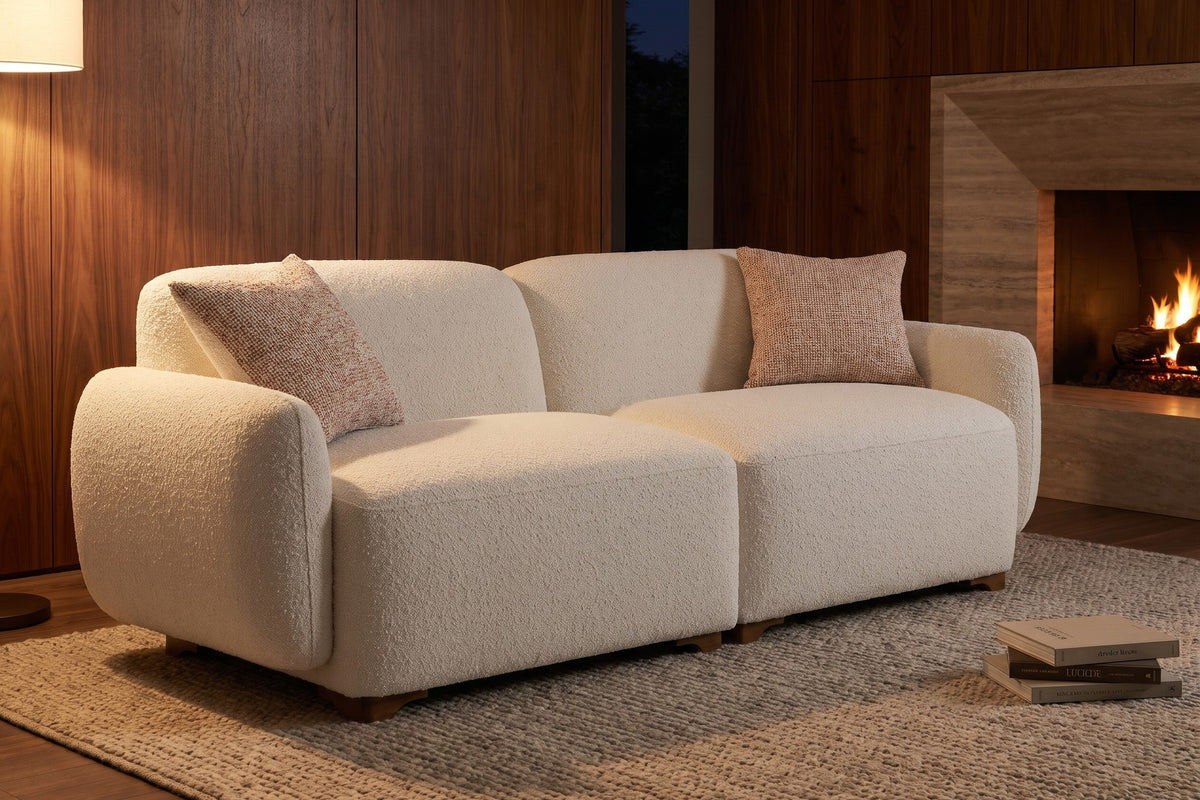 Evening. By the fire, two textured toss pillows warm up the cream bouclé.