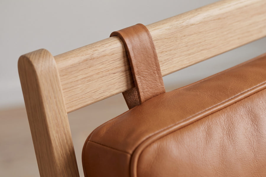 Étretat Bentwood Oak and Cognac Leather Lounge Chair: close-up of the leather strap that hangs the cognac back cushion from the oak top rail