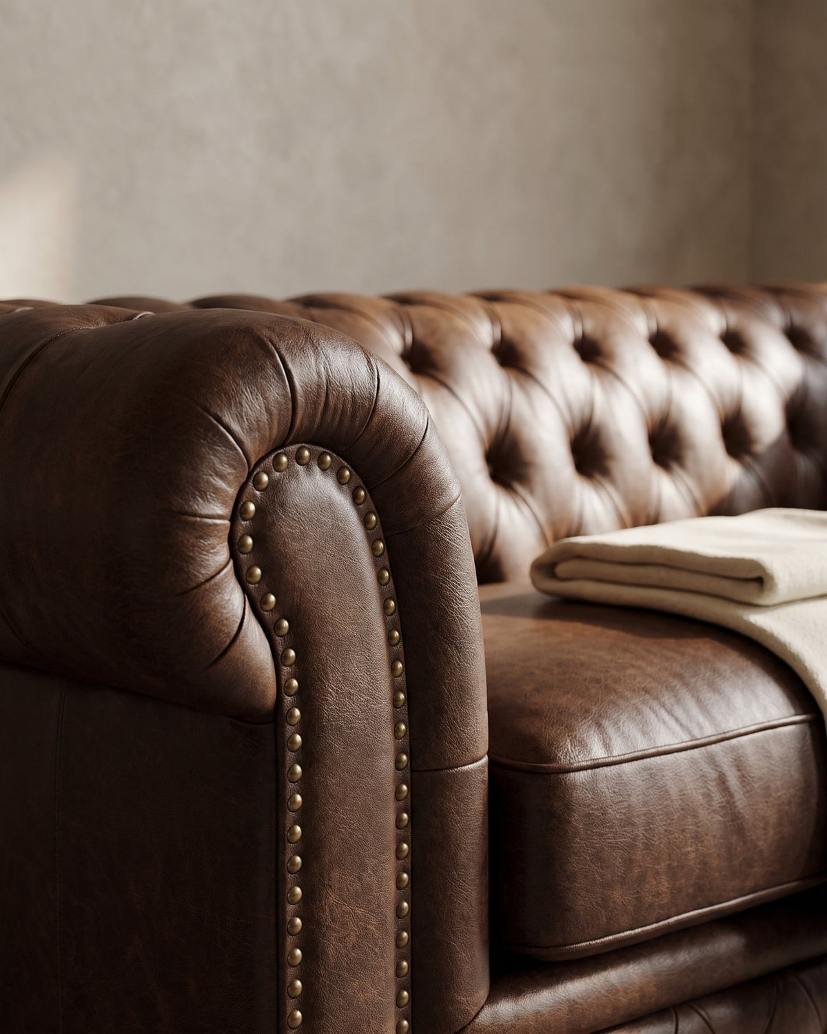 Close-up of the Figaro Chesterfield sofa's chocolate leather, button tufting and nailhead trim