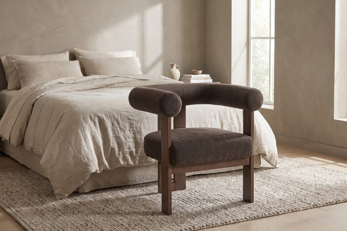 Bedroom. At the foot of the bed, dark brown velvet gives a pale room some weight.