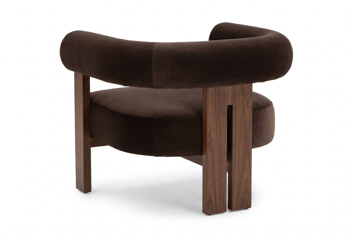 Gaspard dark brown velvet accent chair with a round bolster back and walnut-finish base, back three-quarter view on a white background