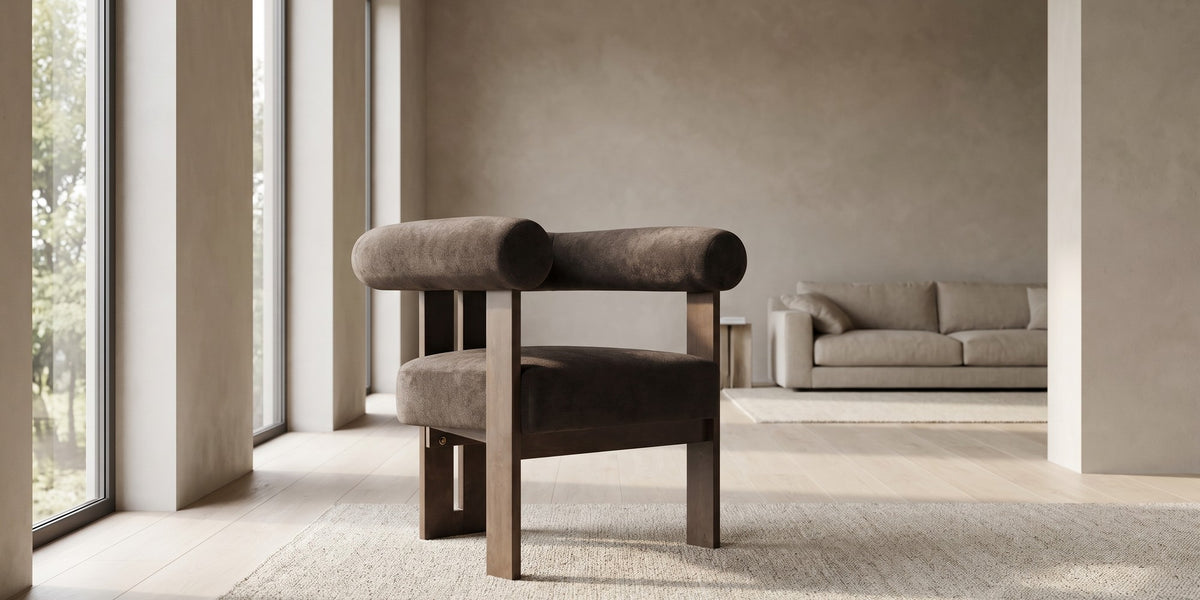 Gaspard dark brown velvet accent chair with a round bolster back and walnut-finish base in a wide, calm living room