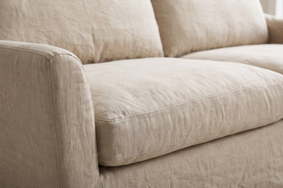 Germain 90" Slipcovered Linen-Blend Sofa: close-up of the natural linen-blend slipcover on a seat cushion and arm, showing the slub texture of the linen and its soft folds