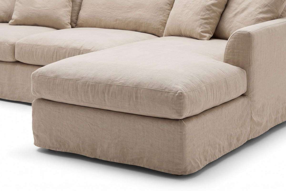 Germain Natural Linen Slipcovered Chaise Sectional: close-up of the natural linen-blend slipcover on the chaise cushion and the rounded arm beside it, showing the slub texture of the linen and its soft folds
