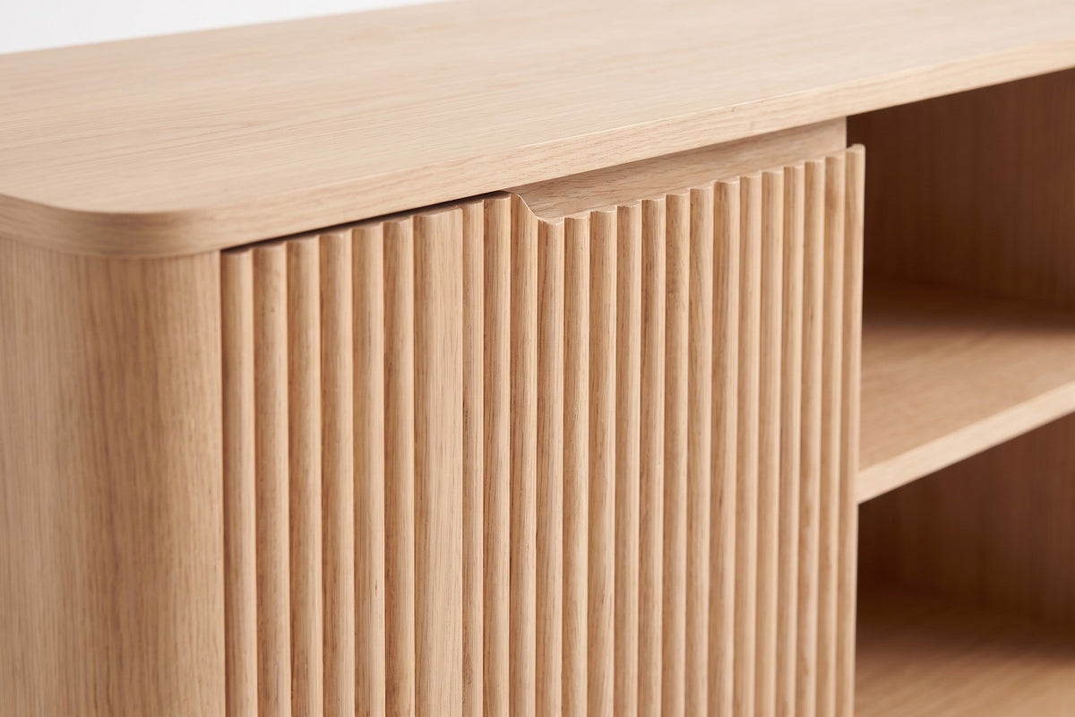 Gordes Fluted Oak Media Console: close-up of the vertical oak fluting on one door and the routed finger pull along its top edge