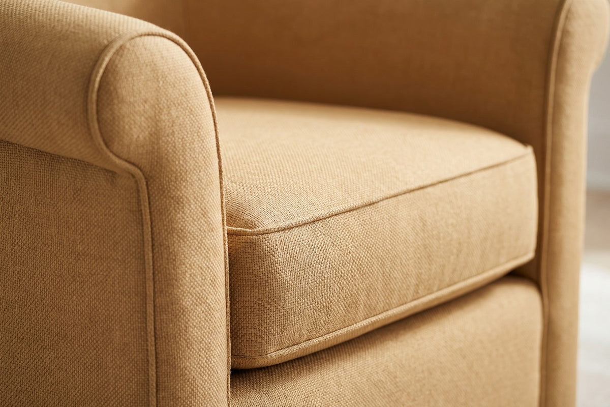 Hossegor Camel Swivel Club Chair: close-up of the welted edge of the plump seat cushion inside the curve of the arm