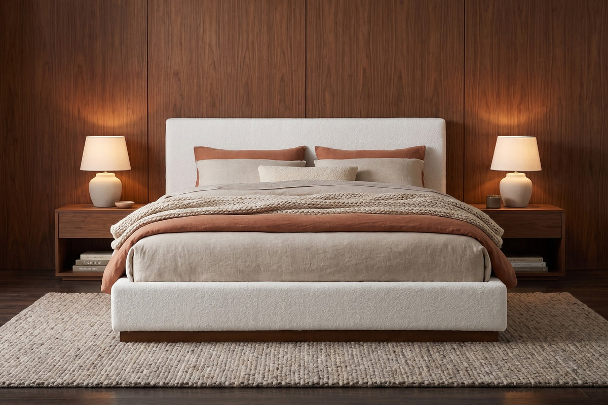 Jeanne white upholstered bed with a brown rubberwood base in a warm walnut-panelled bedroom in the evening