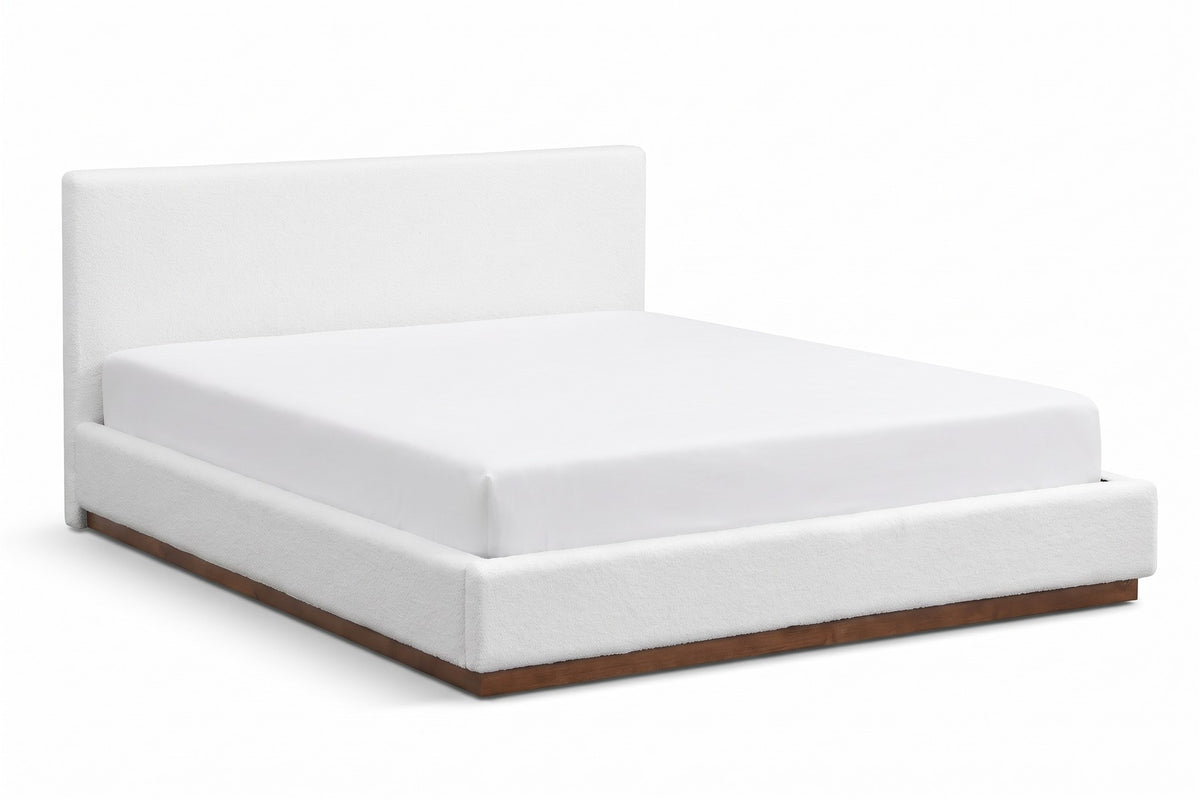 Jeanne white upholstered bed with a brown rubberwood base, three-quarter front view from slightly above on a white background