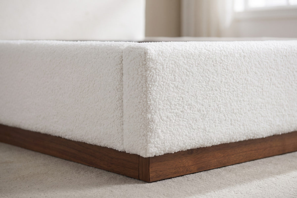 Close-up of one foot corner where the white teddy-fabric rail sits on the brown wood-grain base (Jeanne)