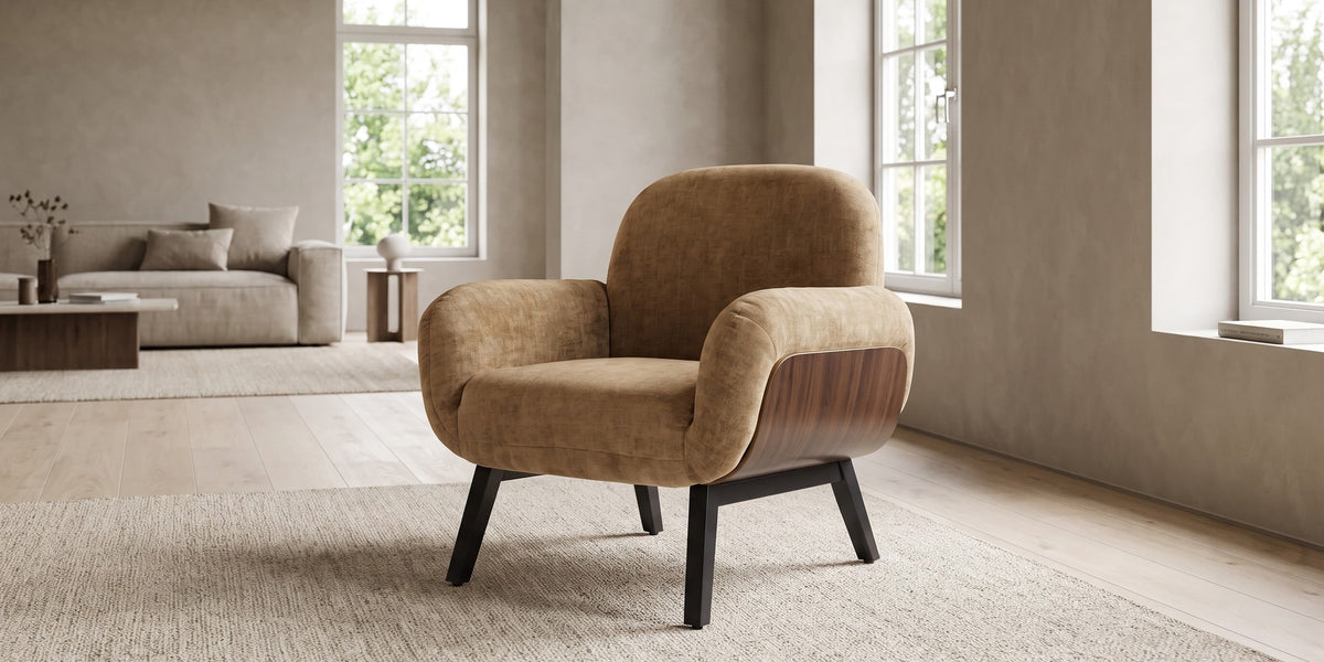 Lucie tan upholstered armchair with walnut-finish side panels and black legs in a wide, calm living room