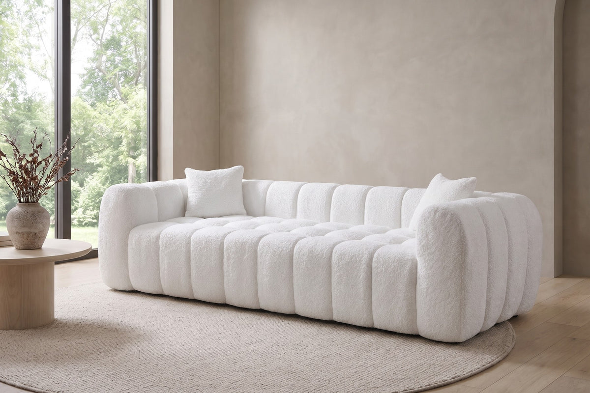 In a calm, daylit room, the white channels run the full length of the sofa.