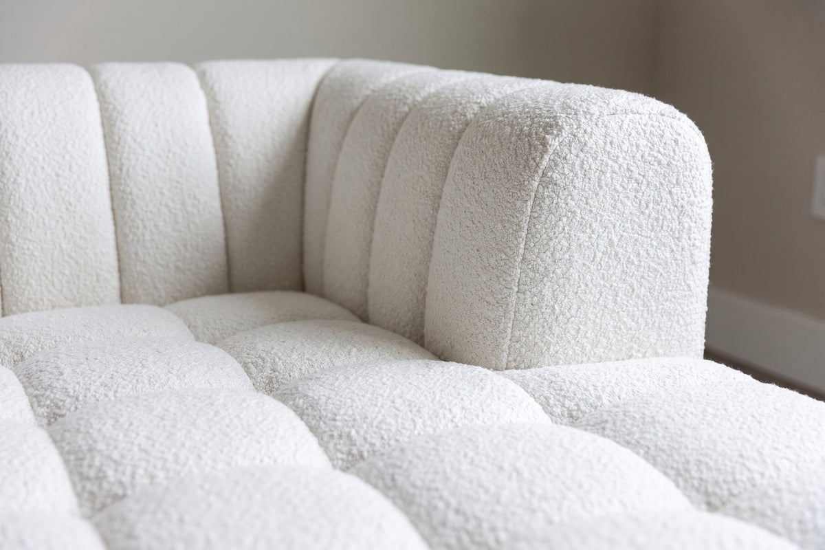 Close-up of the white bouclé where a channel-tufted arm meets the square-tufted seat (Madeleine)