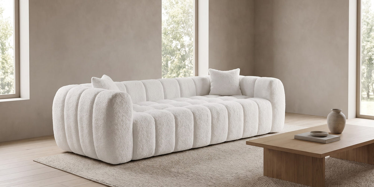 Madeleine 102.7" white bouclé channel-tufted sofa in a wide room view