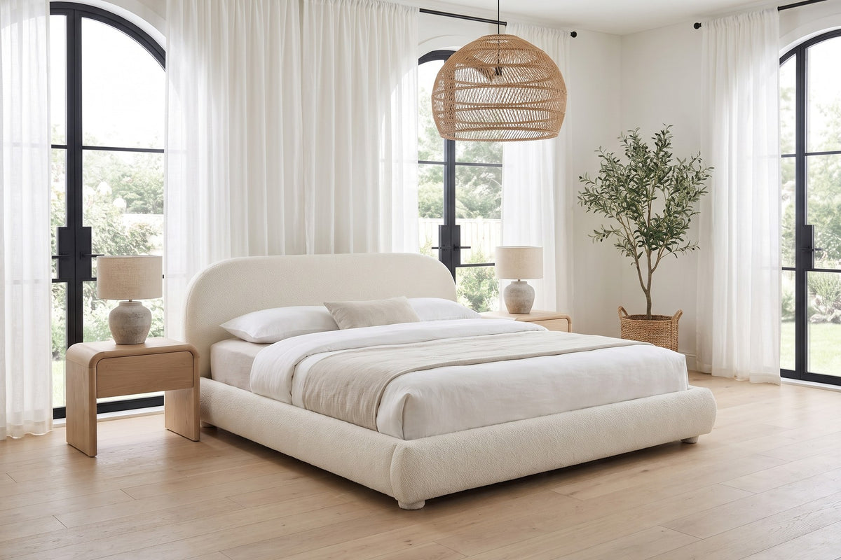 Manon cream bouclé bed with an arched headboard in a bright bedroom with tall arched windows