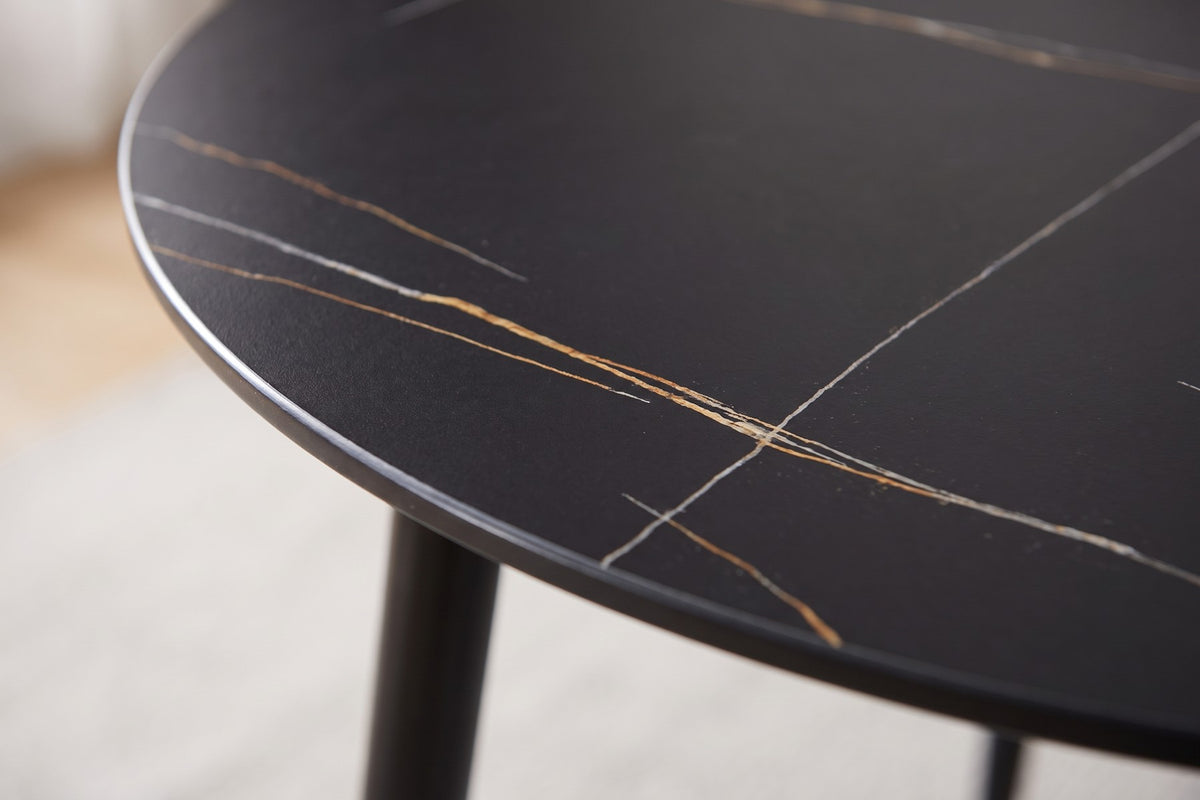Close-up of the Marais table's black sintered stone top with gold veining and its thin edge