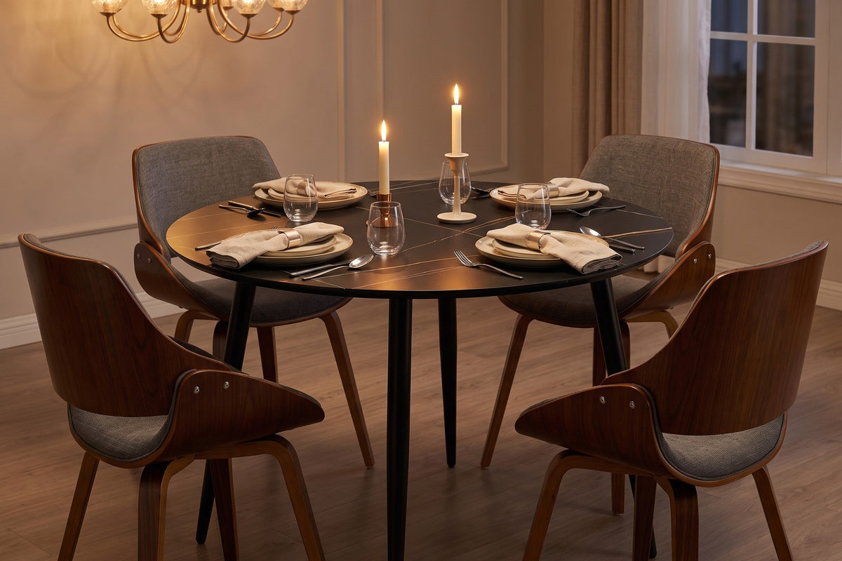 Marais round black dining table set for dinner for four with candles and bentwood chairs