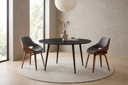 Marais round black sintered stone dining table with grey and walnut bentwood dining chairs in a calm daylit dining room